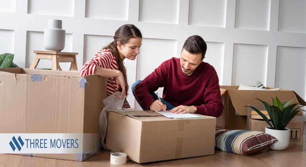 Couple labeling moving boxes and organizing belongings before moving into a new home